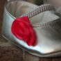 A pair of silver and red baby shoes